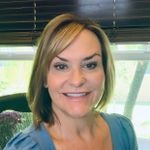 A person smiling and wearing a tie.